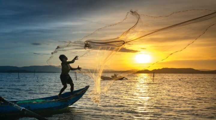 young boy in fishing boat sunset